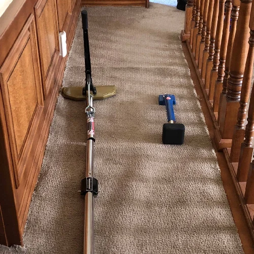 Carpet power stretcher and knee kicker on a hallway carpet.