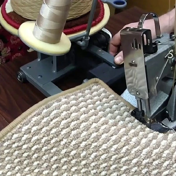 carpet serging machine finishing the edge of a tan patterned rug.